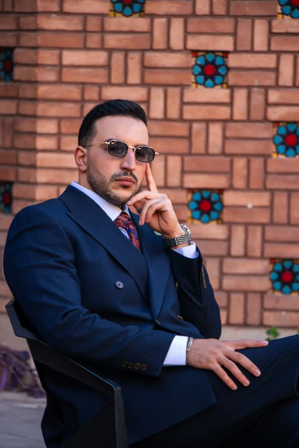 Abdollah Mohammadpour seated, in thought, wearing a navy suit